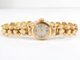 a close up of a gold wrist watch on a white surface