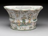 a white bowl with green and yellow designs on it