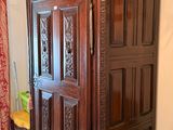 a wooden armoire in the corner of a room with a yellow chair