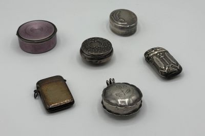 un petit assortiment d'objets en argent posés sur une surface blanche