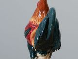 a figurine of a rooster sitting on a table