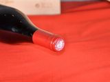 a bottle of wine sitting on a red table cloth
