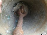 a person holding a rusty bell on a wooden bench