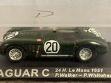 a green toy car in a clear box on a table