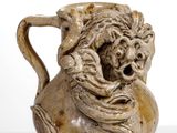un vase marron sur lequel est représenté un visage