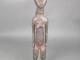 statue d'un homme portant une chaussure rouge, posée sur une surface grise