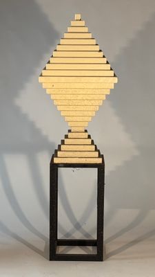 a wooden sculpture of a geometric shape on a stand