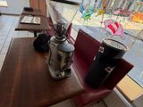 a table with a coffee pot on it in front of a window
