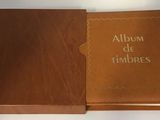 Un album de timbres s'ouvre sur une surface blanche