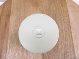 a white plate with a chanel logo on it sitting on a wooden table