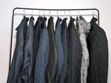 a lot of jackets hanging on a rack in a room