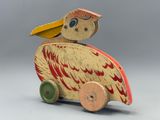 a wooden toy of a pelican sitting on top of a cart
