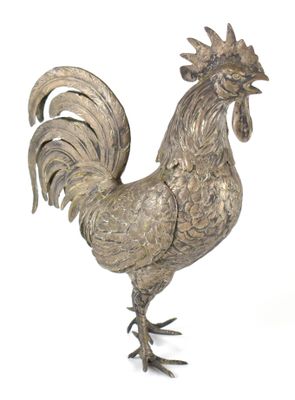 une statue en argent représentant un coq sur fond blanc