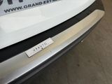 the rear bumper of a white car with a sticker on it