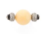 a close up of a yellow bead with two black and white beads