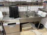une cuisine équipée d'un évier, d'une cuisinière et d'une poubelle