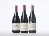 three bottles of wine are lined up on a table