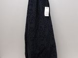 the black dress is hanging on a hanger on the wall