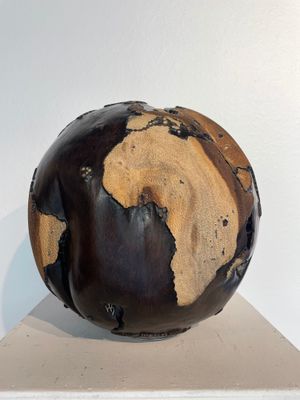a sculpture of a brown and black globe on top of a white shelf
