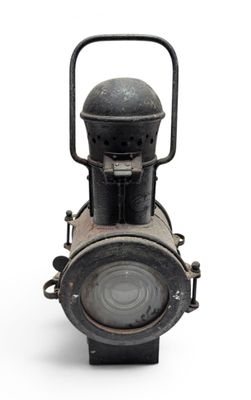 an old fashioned lantern that is sitting on a white surface