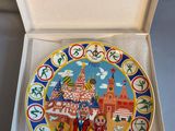 an open box with a decorative plate inside of it on a table