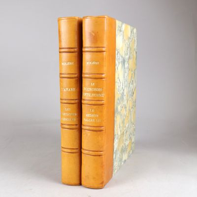 deux livres jaunes posés l'un sur l'autre devant un fond gris