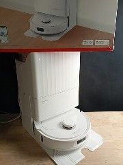 une cuvette de WC blanche posée sur une table en bois