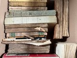 many books stacked on top of each other in a box