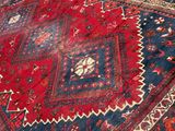 an image of a red and blue oriental rug on a wooden floor