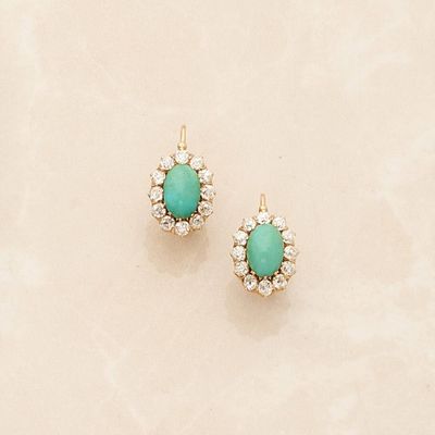 pair of turquoise and diamond stud earrings on a marble surface