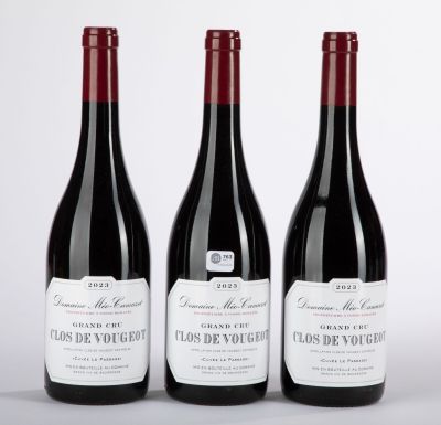 trois bouteilles de vin rouge posées sur une table blanche