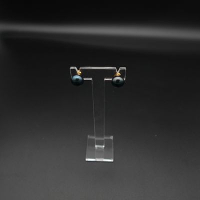 un gros plan sur une paire de boucles d'oreilles posées sur un présentoir transparent