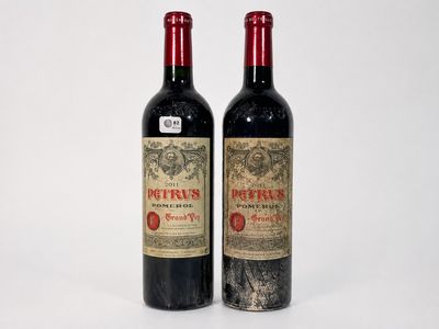 two bottles of red wine sitting next to each other on a white surface