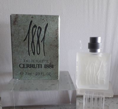 un flacon de parfum posé sur une table à côté d'une boîte