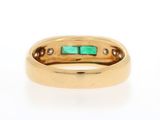a close up of a gold ring with a green stone in it