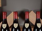 three bottles of red wine sit in a wooden box on a table