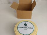 le récipient se trouve à côté d'une boîte de crème d'orcile