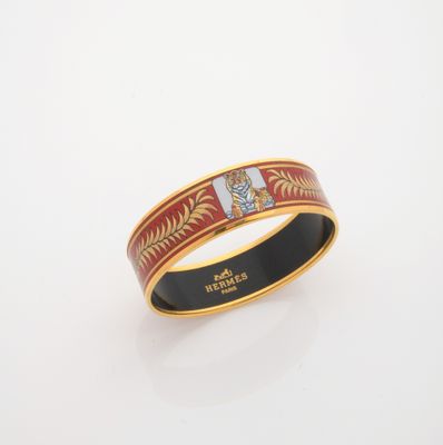 a close up of a gold ring with a red and white design