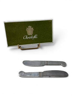 two knifes and a knife holder with a green box on a white background