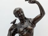statue of a woman holding a bird and a bird in her hand