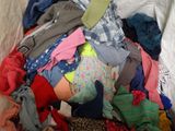 a pile of clothes that is on a bed