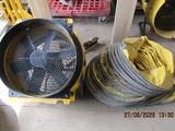 deux tuyaux jaunes et un ventilateur noir posés par terre