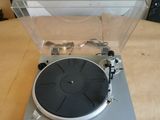 Le tourne-disque est posé sur une table en bois.