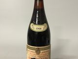 an old bottle of wine sitting on top of a white table