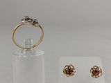 a close up of a pair of earrings and a ring on a display