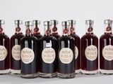 six bouteilles de vin sont alignées sur une surface blanche