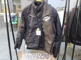 une veste noire suspendue à un portant dans un magasin