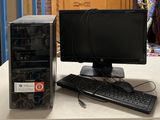 un ordinateur de bureau posé sur une table à côté d'un clavier et d'une souris