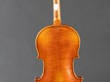 an old violin on a stand against a gray background