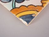 a close up of a tile with a flower on it